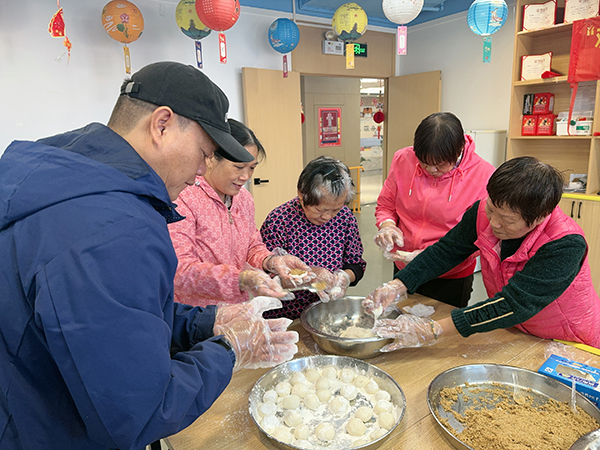 图：残疾人分工合作制作汤圆